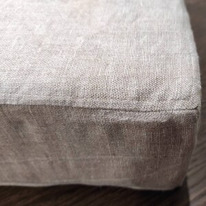 Puede incluir: Un coj&iacute;n de lino beige con una costura alrededor del borde.