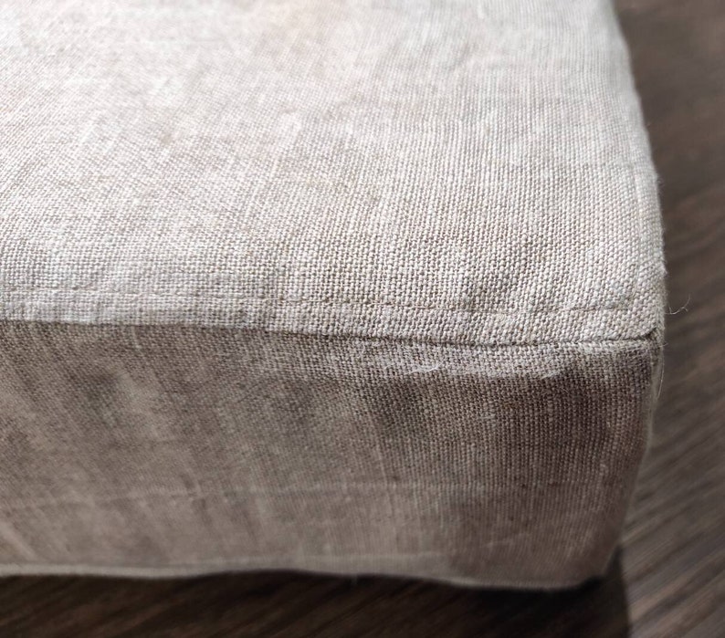 Puede incluir: Un coj&iacute;n de lino beige con una costura alrededor del borde.
