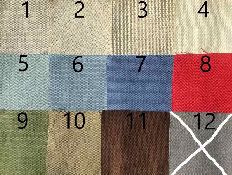 May include: A swatch card with 12 different fabric samples. The samples are numbered 1 through 12. The fabrics are in a variety of colors and textures, including beige, blue, red, green, and gray.