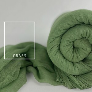 May include: A soft, green fabric rolled up with the word "GRASS" printed on it.