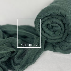 May include: A dark olive green fabric backdrop, rolled up and ready to use. The fabric is soft and flowing, perfect for photography or crafting.
