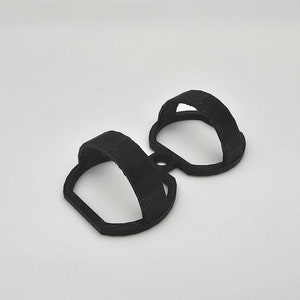 May include: A black plastic 3D printed double hook. The hook is designed to hold two items.