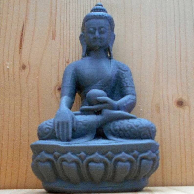 May include: A gray stone statue of a seated Buddha with a lotus base. The Buddha is meditating with hands in the Dhyana mudra position.
