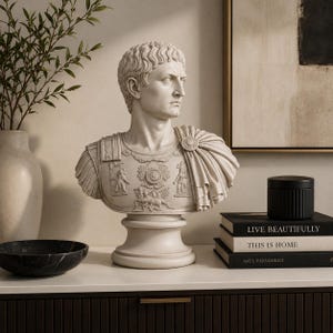 Augustus Caesar sculpture displayed on a stone pedestal surrounded by classical Roman columns and ancient architecture.