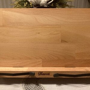 May include: A wooden book stand with a black metal page holder. The stand is engraved with the name "Maureen".