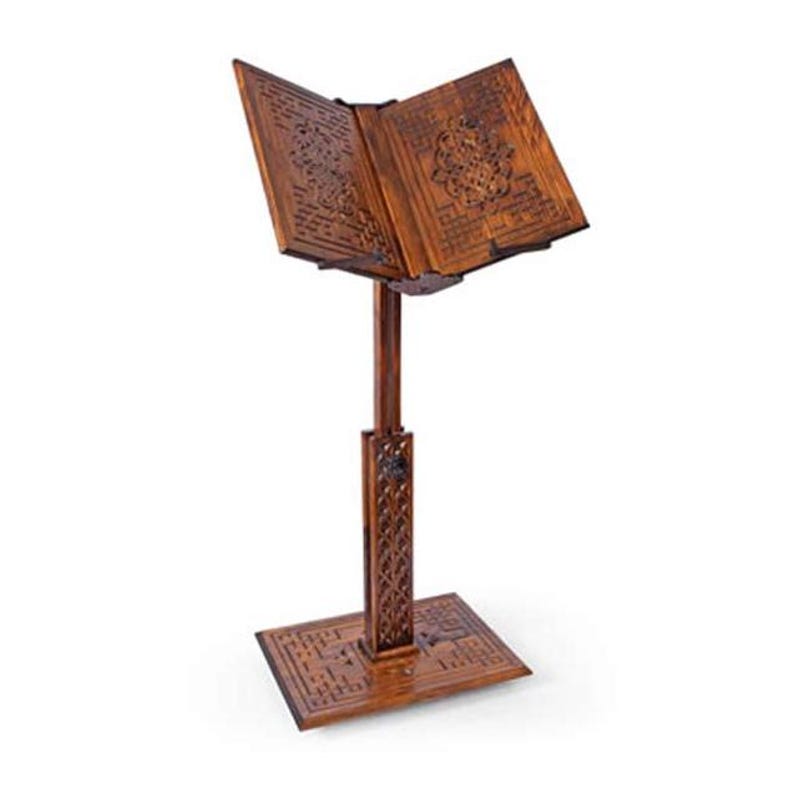 May include: A brown wooden book stand with an open book. The stand features detailed carvings on the base, stem, and book rest. The book rest is angled, and the stand is approximately 100 cm tall.