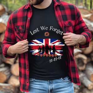 May include: A black t-shirt with a white graphic of a Union Jack flag with soldiers and the text "Lest We Forget" and "11-11-11".