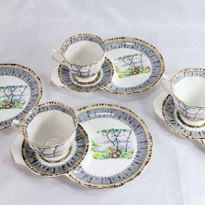 Puede incluir: Juego de t&eacute; vintage con seis tazas, platillos y platos. Cada pieza presenta un paisaje con un &aacute;rbol y un borde azul y dorado. Ideal para disfrutar de una buena taza de t&eacute;.