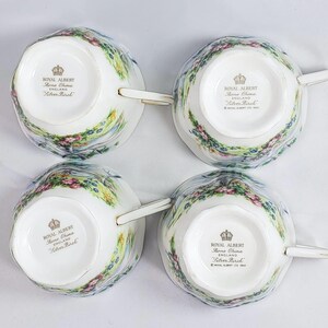 Puede incluir: Cuatro tazas de t&eacute; de porcelana fina Royal Albert Silver Birch. Cada taza presenta un dise&ntilde;o de paisaje con flores rosas y moradas, follaje verde y un cielo azul claro. Las tazas tienen ribetes y asas doradas.