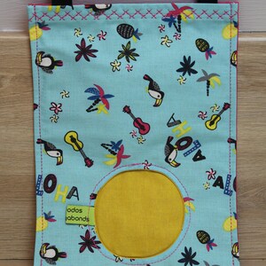 May include: A blue fabric storage bag with a yellow circle in the center. The bag has a tropical print with toucans, palm trees, pineapples, flowers, and guitars. The text "ALOHA" is printed on the bag.