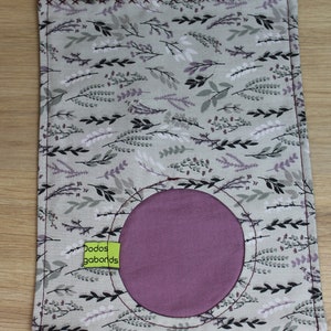 May include: A gray fabric pouch with a purple circle in the center. The pouch has a floral pattern with black and white leaves and a green label that says "Dodos gobands".