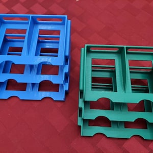 May include: Three blue and three green plastic storage containers stacked on top of each other. Each container has two compartments.