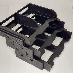 May include: Black plastic organizer with multiple compartments, designed to hold small items. The organizer is made of two stacked levels, each with several slots.