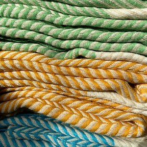 May include: A stack of folded towels in green, yellow, and blue with a chevron pattern.