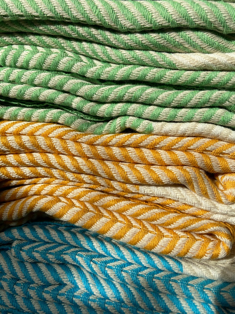 May include: A stack of folded towels in green, yellow, and blue with a chevron pattern.