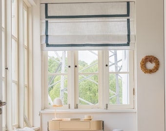 Cortinas romanas de lino personalizadas, blancas con ribete de color, pliegues planos y cenefa recta.