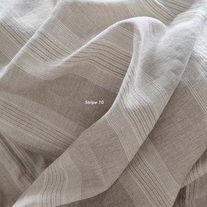 Puede incluir: Primer plano de una tela a rayas de color marr&oacute;n claro y blanco. La tela est&aacute; tejida con una textura sutil y tiene una sensaci&oacute;n suave y fluida. La tela est&aacute; etiquetada como "Stripe 10".