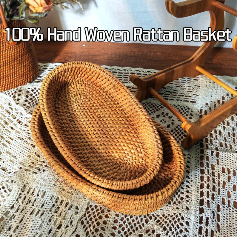 May include: Two oval-shaped woven rattan baskets, one nested inside the other. The baskets are made of natural brown rattan and have a hand-woven design. 100% Hand Woven Rattan Basket.