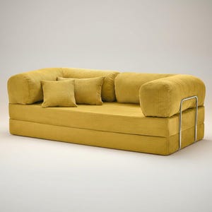 May include: A yellow corduroy sofa with two square and two cylindrical pillows. The sofa has a modern design with a metal armrest and measures approximately 75 inches long.