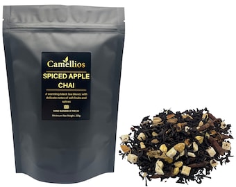 May include: A black resealable pouch with a gold label that reads "Camellios Spiced Apple Chai". The label also includes the text "A warming black tea blend, with delicate notes of soft fruits and spices. Hand blended in the UK. Minimum Net Weight: 200g". A pile of loose leaf tea is shown next to the pouch.