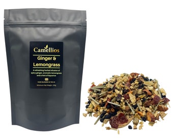 May include: A black resealable pouch with a white label that reads "Camellios Ginger & Lemongrass". The label also includes a description of the tea blend and the text "HAND BLENDED IN THE UK" and "Minimum Net Weight 200g". A pile of loose leaf tea is shown in front of the pouch. The tea blend includes dried ginger, lemongrass, and other herbs.
