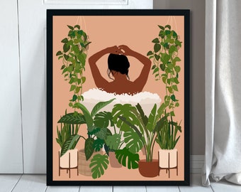 May include: Art print in a black frame depicting a person in a bathtub, surrounded by green plants. The illustration has a warm colour palette with a peach background. The person has dark skin and dark hair, with their arms raised.