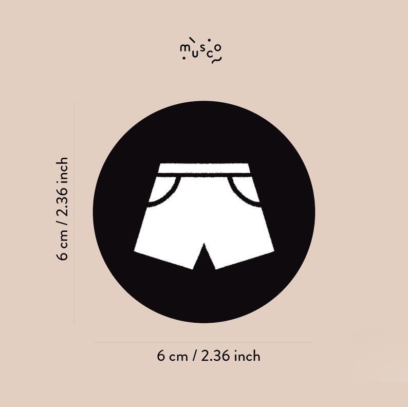 May include: Black and white illustration of a pair of shorts on a black circle. The circle is 6 cm in diameter.