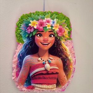 May include: A colorful pinata featuring Moana from the Disney movie Moana. The pinata is shaped like Moana's head and shoulders, with her signature brown hair, brown eyes, and a flower crown. She is wearing a red and white top and a necklace with a seashell pendant. The pinata is decorated with pink, green, and blue tissue paper.
