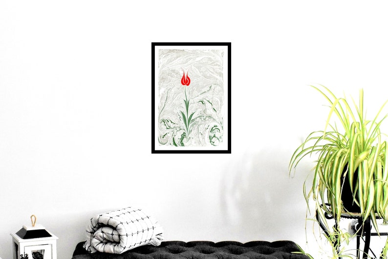 Puede incluir: Una impresi&oacute;n enmarcada de un tulip&aacute;n rojo con hojas verdes sobre un fondo marmoleado blanco y verde.