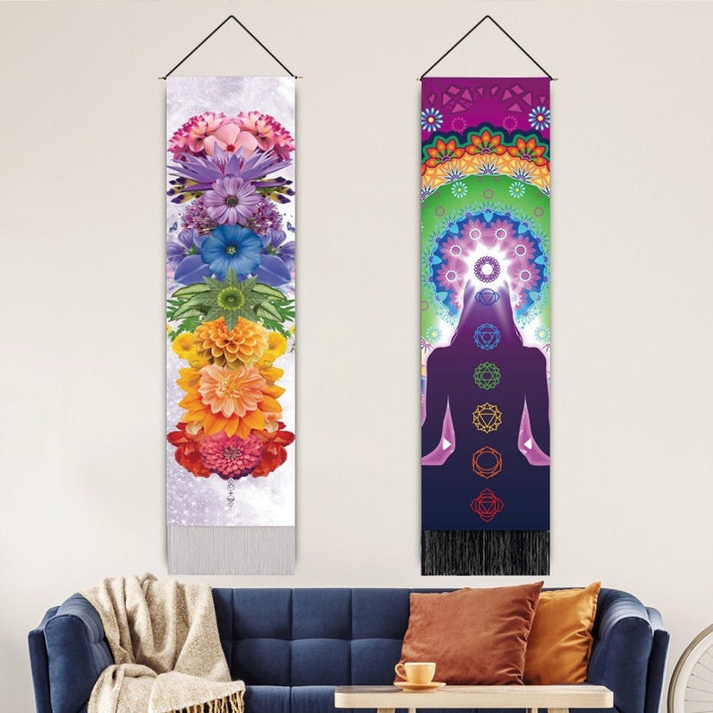 May include: Two wall tapestries with a spiritual theme. The tapestry on the left features a stack of colorful flowers, each representing a chakra. The tapestry on the right features a person in a meditative pose with the seven chakras represented by colorful symbols.