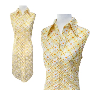 May include: A sleeveless yellow and white dress with a daisy print and a button-up front.
