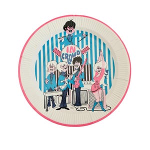 May include: A white ceramic mug with a black handle and the text "But First, Coffee" in a bold, black font. The mug is set against a blurred background, suggesting a cozy setting.