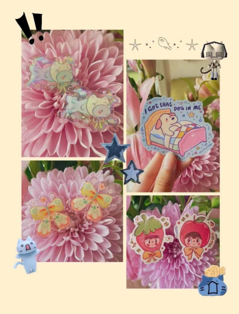 May include: A collection of colorful stickers featuring a dog in a bed with the text I Got That DOG IN ME, butterfly shapes, and characters wearing strawberry and apple costumes, all displayed against a background of pink chrysanthemum flowers.