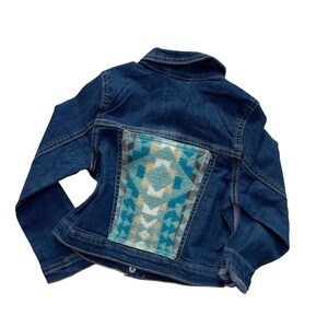 May include: A dark blue denim jacket with a geometric patterned fabric patch on the back.