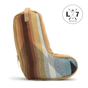 May include: A tan leather boot bag with a zipper and a colorful woven pattern. The bag is made by L7 AZ Designs.