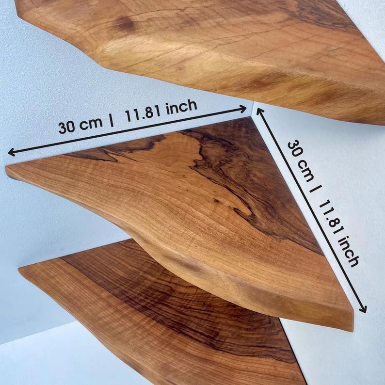 May include: Three wooden corner shelves, each with a unique grain pattern. The shelves are approximately 11.81 inches (30 cm) in length. The shelves are a warm brown color and appear to be made from a single piece of wood.