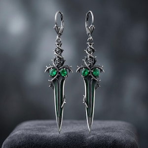 Gotische oorbellen in de vorm van een doorndolk, gemaakt van sterling zilver met een briarblad en een synthetische smaragd, geoxideerd en op bestelling vervaardigd.