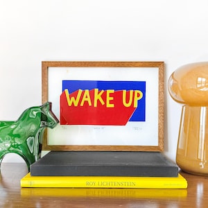 Impresión linográfica enmarcada "Despierta" – Impresión manual de edición limitada, decoración de pared, regalo para amantes del arte pop, rojo, azul y amarillo, colores vibrantes