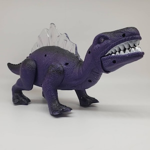 Vintage speelgoed dinosaurus spinosaurus: wandelend figuurtje met licht en geluid