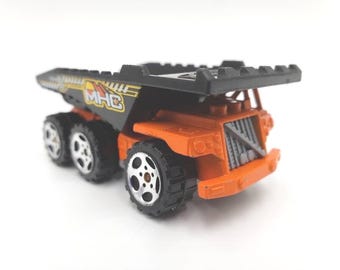Caminhão basculante Matchbox vintage de 3 eixos, laranja, para mudanças pesadas, em miniatura.