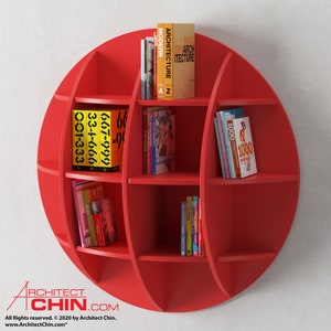 Pode incluir: Uma estante circular vermelha com seis prateleiras. As prateleiras est&atilde;o cheias de livros com v&aacute;rios t&iacute;tulos, incluindo "Modern Architecture", "667-999" e "1000".