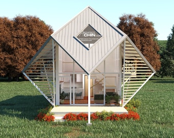 May include: A white, modern, diamond-shaped house with large windows and a wooden deck. The house is surrounded by green grass and trees.