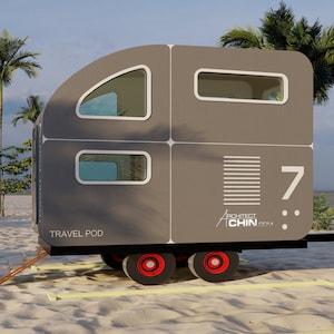 May include: A gray travel trailer with a rounded roof and windows. The trailer has the text "TRAVEL POD" and "ARCHITECT CHIN" on the side. The trailer is parked on a sandy beach with palm trees in the background.