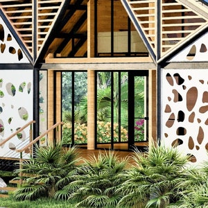 May include: A modern, sustainable home with a unique design featuring a white, geometric pattern on the exterior walls. The home has large windows and a wooden deck.