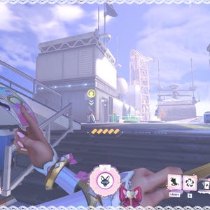 May include: A first-person view of a video game scene. The player's character holds a pink and blue weapon with a circular emblem. The game interface displays health and ability icons, set against a futuristic cityscape.