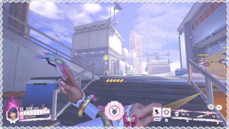 May include: A first-person view of a video game scene. The player's character holds a pink and blue weapon with a circular emblem. The game interface displays health and ability icons, set against a futuristic cityscape.