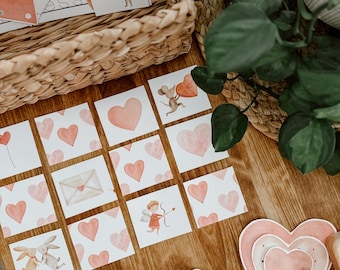 May include: A set of Valentine's Day themed matching game cards featuring illustrations of animals, hearts, and other romantic symbols. The cards are printed on white cardstock and have a pink and red color scheme.