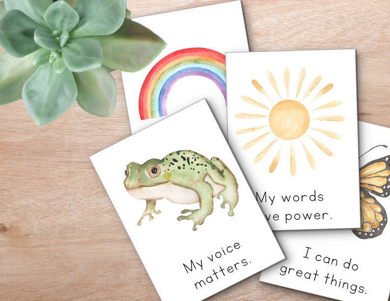 Peut inclure: Quatre cartes aquarelle avec des affirmations positives. Les cartes pr&eacute;sentent un arc-en-ciel, un soleil, une grenouille et un papillon. Le texte sur les cartes est : "Ma voix compte", "Mes mots ont du pouvoir", "Je peux faire de grandes choses".