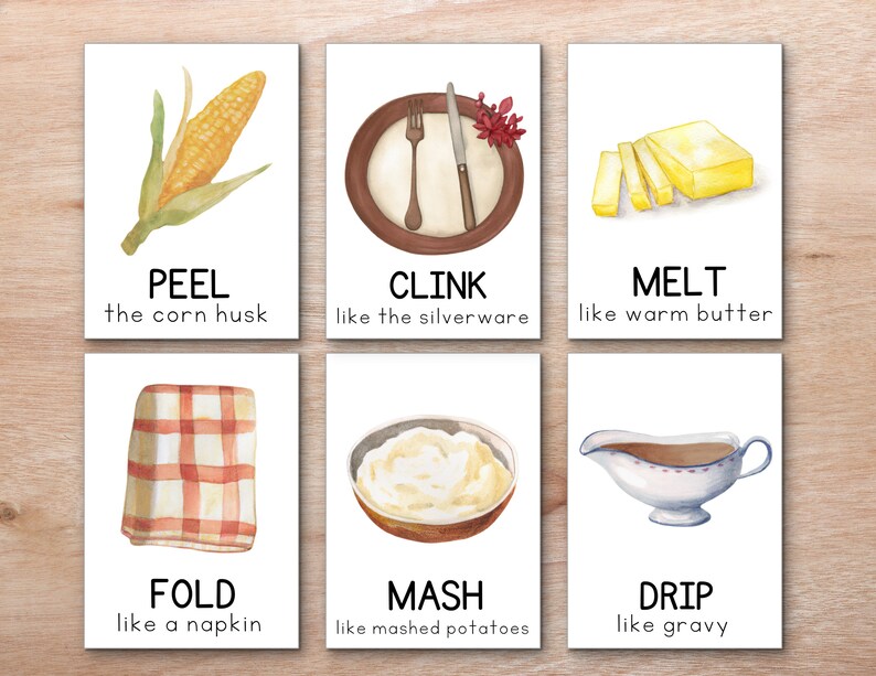 K&ouml;nnte beinhalten: Sechs illustrierte Karten mit Thanksgiving-bezogenen Verben und Bildern. Die Karten zeigen einen Maiskolben, Besteck, Butter, eine Serviette, Kartoffelp&uuml;ree und So&szlig;e. Jede Karte hat ein Verb und eine Beschreibung der Aktion, wie "PEEL the corn husk" und "CLINK like the silverware".