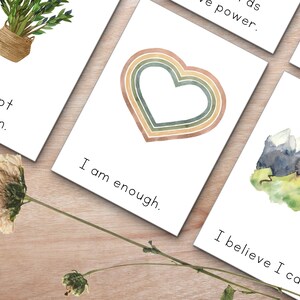 Peut inclure: Quatre cartes d'affirmation avec des illustrations &agrave; l'aquarelle. Les cartes pr&eacute;sentent les phrases "J'accepte qui je suis", "Je suis assez", "Je crois que je peux", et "J'ai le pouvoir".